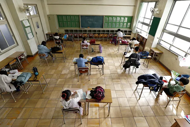 Students sit apart from each other as they do self-study at an elementary school where the facility was opened for children who cannot stay at home alone while their parents are at work, in Nagoya, central Japan on March 3, 2020. (Photo by Kyodo News via Reuters)