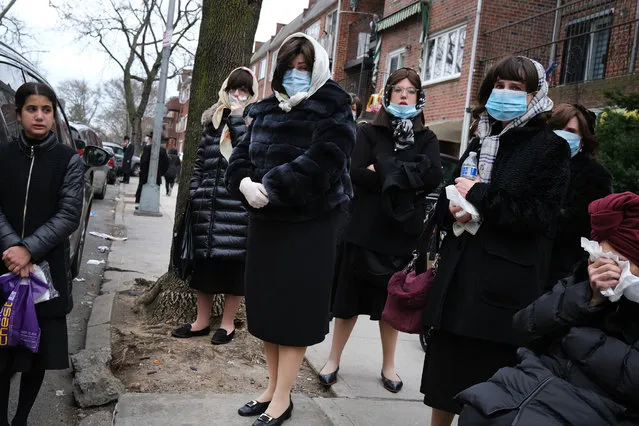 Women wear face masks as they join hundreds of members of the Orthodox Jewish community attending the funeral for a rabbi who died from the coronavirus in the Borough Park neighborhood which has seen an upsurge of (COVID-19) patients during the pandemic on April 05, 2020 in the Brooklyn Borough of New York City. Hospitals in New York City, which has been especially hard hit by the coronavirus, are facing shortages of beds, ventilators and protective equipment for medical staff. Currently, over 122,000 New Yorkers have tested positive for coronavirus. (Photo by Spencer Platt/Getty Images)