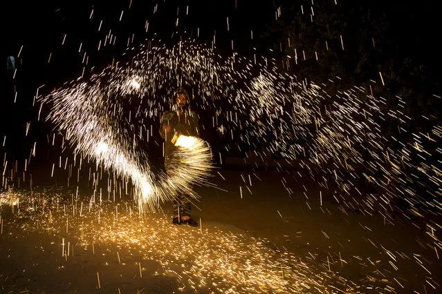 A Palestinian plays with fireworks as he celebrates the start of the Muslim holy month of Ramadan in the West Bank city of Nablus, Thursday, April. 23, 2020. (Photo by Majdi Mohammed/AP Photo)