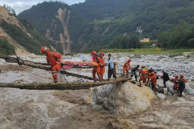 In this photo released by Xinhua News Agency, rescuers transfer survivors across a river following an earthquake in Moxi Town of Luding County, southwest China's Sichuan Province Monday, September 5, 2022. Dozens people were reported killed and missing in an earthquake that shook China's southwestern province of Sichuan on Monday, triggering landslides and shaking buildings in the provincial capital of Chengdu, whose 21 million residents are already under a COVID-19 lockdown. (Photo by Cheng Xueli/Xinhua via AP Photo)