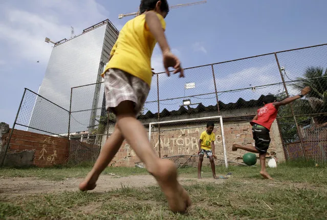 Children play soccer in the Vila Autodromo slum in Rio de Janeiro, Brazil, July 28, 2015. (Photo by Ricardo Moraes/Reuters)