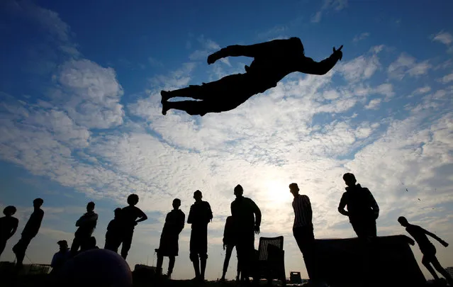 Iraqi demonstrators perform a somersault as they practice parkour during ongoing anti-government protests, near the Tigris River in Baghdad, Iraq, December 9, 2019. (Photo by Alaa al-Marjani/Reuters)