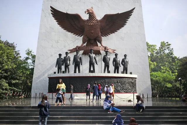 In this Sunday, October 15, 2017, photo, visitors take photos taken near the statues of the seven Army officers who were killed in an abortive coup in 1965 that the military blamed on Indonesia's Communist Party and subsequently led to the anti-communist purge in 1965-1966, at Pancasila Sakti Monument in Jakarta, Indonesia. Declassified files have revealed new details of American government knowledge and support of an Indonesian army extermination campaign that killed several hundred thousand civilians during anti-communist hysteria in the mid-1960s. (Photo mby Dita Alangkara/AP Photo)