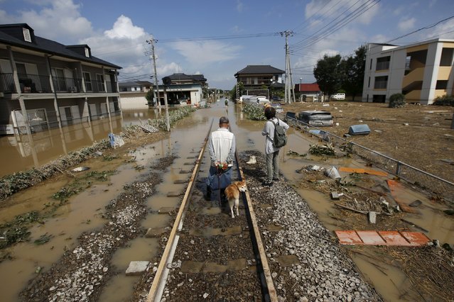 Local residents walk along a railway at a residential area flooded by the Kinugawa river, caused by typhoon Etau, at Mitsukaido district in Joso, Ibaraki prefecture, Japan, September 12, 2015. (Photo by Issei Kato/Reuters)