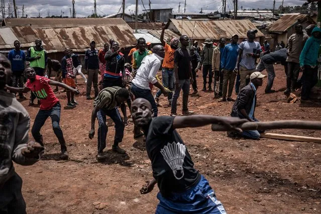 Protesters throw stones during clashes with police forces in the Kibera district, Nairobi, on October 26, 2017. Kenyans trickled into polling stations today for a repeat election that has polarised the nation, amid sporadic clashes as supporters of opposition leader ignored his call to stay away and tried to block voting. (Photo by Marco Longari/AFP Photo)