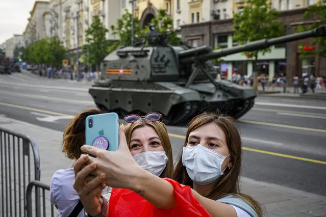 Womentake a selfie in front Russian military vehicles during a rehearsal for the WWII Victory Parade in Moscow on June 17, 2020. Russia's President Putin on June 24 will preside over a massive military parade to mark Soviet victory in World War II, which was postponed due to the coronavirus pandemic. (Photo by Dimitar Dilkoff/AFP Photo)