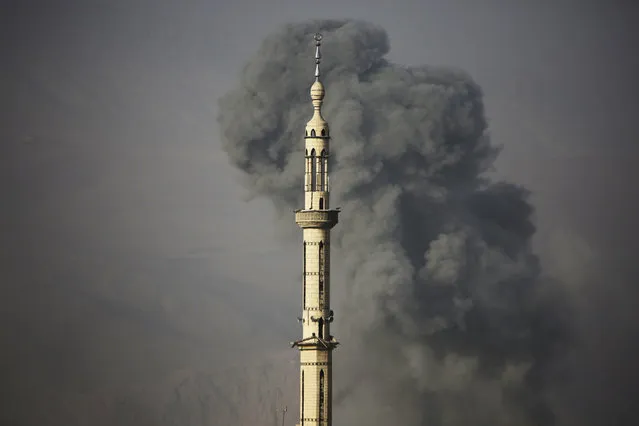 Smoke rises following an air strike on the rebel-held besieged town of Harasta, in the Eastern Ghouta region on the outskirts of Damascus, on November 15, 2017. (Photo by Amer Almohibany/AFP Photo)