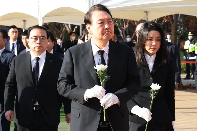 South Korean President Yoon Suk Yeol, center, and his wife Kim Keon Hee arrive to pay tribute for victims of a deadly accident following Saturday night's Halloween festivities at a joint memorial altar for victims at Seoul Square in Seoul, South Korea, Monday, October 31, 2022. (Photo by Ahn Jung-hwan/Yonhap via AP Photo)