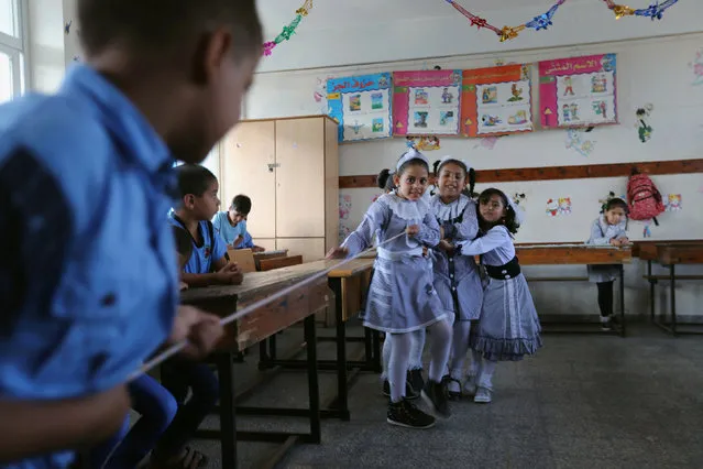 Palestinian schoolchildren play a game in a classroom on the first day of a new school year, at a United Nations-run school in Khan Young in the southern Gaza Strip August 28, 2016. (Photo by Ibraheem Abu Mustafa/Reuters)