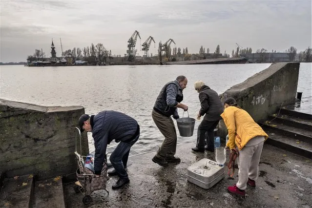 Residents of the recently liberated city of Kherson collect water from the Dnipro river bank, near the frontline, southern Ukraine, Monday, November 21, 2022. (Photo by Bernat Armangue/AP Photo)