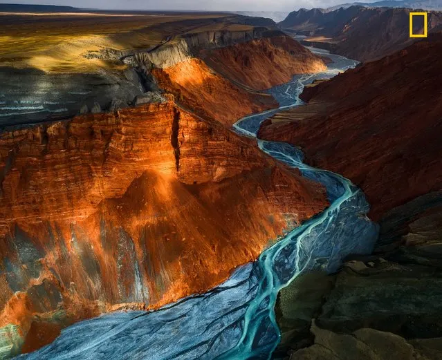2nd Place in Landscapes: Sunlight glances off mineral strata of different colors in Dushanzi Grand Canyon, China. (Photo by Yuhan Liao/National Geographic Nature Photographer of the Year contest 2017)