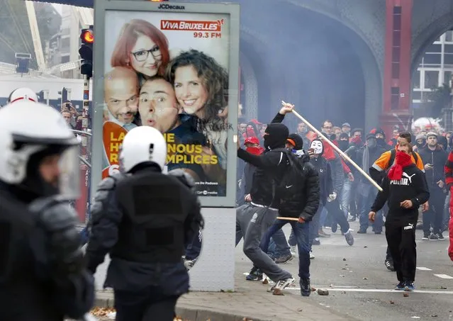 A demonstrator smashes an advertising panel during clashes at a march against government reforms and cost-cutting measures in Brussels , October 7, 2015. (Photo by Yves Herman/Reuters)