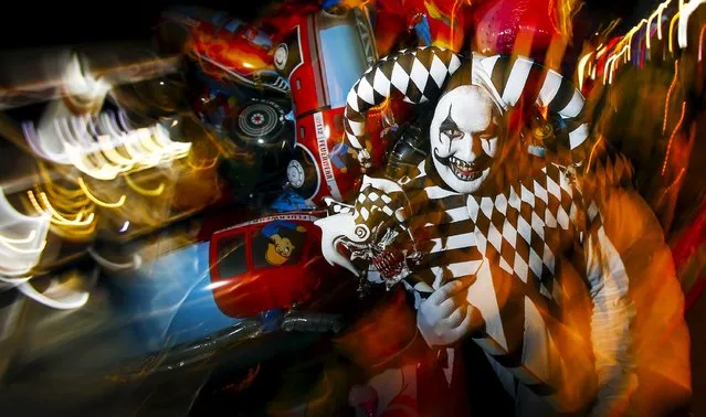 A man dressed as a horror clown promotes an upcoming horror show at the Filmpark Babelsberg theme park at Potsdamer Platz square in Berlin, Germany, October 9, 2015. (Photo by Hannibal Hanschke/Reuters)