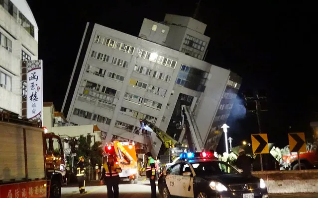 Rescuers are seen entering a building that collapsed onto its side from an early morning 6.4 magnitude earthquake in Hualien County, eastern Taiwan, Wednesday, February 7 2018. Rescue workers are searching for any survivors trapped inside the building. (Photo by Tian Jun-hsiung/AP Photo)