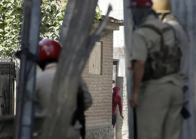 A Kashmiri Muslim protester faces security officers and shouts slogans from a distance in Srinagar, Indian controlled Kashmir, Friday, September 23, 2016. (Photo by Mukhtar Khan/AP Photo)