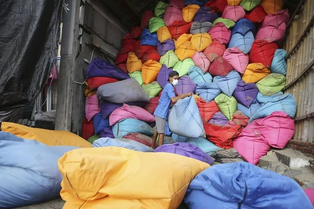 A man prepares beanbag at Kuta beach on the popular tourist island of Bali, Indonesia on  January 20, 2023. The beaches and temples of destinations like Bali and Chiang Mai are the busiest they have been since the pandemic struck three years ago, but they’re still relatively quiet. (Photo by Firdia Lisnawati/AP Photo)