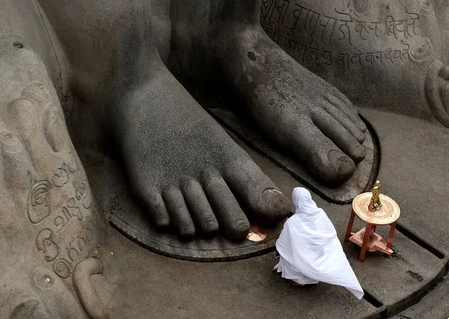 A Jain nun offers prayers at vindyagiri hills by touching the feet of Lord Bhaubali statue on the occasion of the 88th 'Mahamastakabhisheka Mahotsav' ceremony in Shravanabelagola, India, 07 February 2018. The town of Shravanabelagola will attract millions of people from across the country for the head anointing ceremony of the 17-meter-tall statue of Lord Bahubali. The Jain ritual will run from 07 to 26 February and is only held once every 12 years. (Photo by Jagadeesh N.V./EPA/EFE)