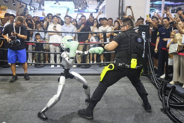 Unitree Robotics' humanoid boxing robot competes against a boxing enthusiast at the exhibition area of the 2025 World AI Conference (WAIC) and High-Level Meeting on Global AI Governance on July 26, 2025 in Shanghai, China. (Photo by Long Wei/VCG via Getty Images)