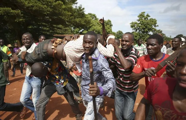 Protesters carry a man who was shot by French soldiers after French troops opened fire at protesters blocking a road in Bambari, in this May 22, 2014 file photo. (Photo by Goran Tomasevic/Reuters)
