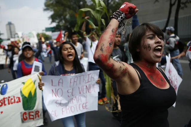 Protestors chant during a march commemorating the anniversary of the Tlatelolco Massacre, in Mexico City, Sunday, October 2, 2016. (Photo by Rebecca Blackwell/AP Photo)
