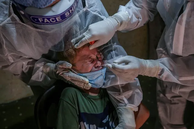 Palestinian medical workers take a swab sample from family member who contacted relatives infected with COVID-19 coronavirus at home in Al Zaitun neighborhood east Gaza City, 29 September 2020 (issued 30 September 2020). The Gaza Strip is under a nationwide lockdown from 25 August. (Photo by Mohammed Saber/EPA/EFE)