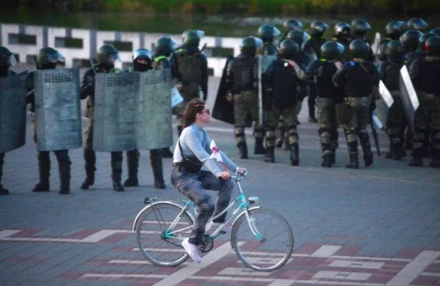 A protester rides her bike in front of Belarusian policemen during a rally to protest against the inauguration of Alexander Lukashenko and against presidential election results in Minsk, Belarus, 23 September 2020. Lukashenko was inaugurated as President of Belarus, state media reported earlier in the day. The move comes after weeks of protests following an election that the opposition says was allegedly rigged. (Photo by EPA/EFE/Stringer)
