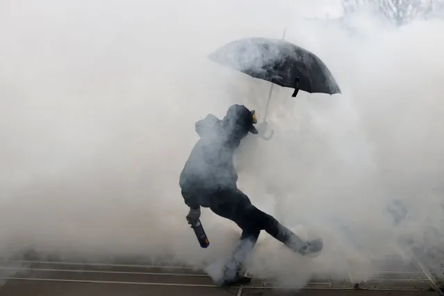 Protesters kicks a teargas canister as he clashes with police during a demonstration in Nantes, western France, Wednesday, March 15, 2023. Opponents of French President Emmanuel Macron's pension plan are staging a new round of strikes and protests as a joint committee of senators and lower-house lawmakers examines the contested bill. (Photo by Jeremias Gonzalez/AP Photo)