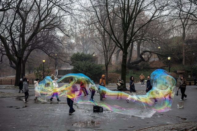 A man makes a giant bubble at Central Park in Manhattan in New York City, U.S., December 28, 2024. (Photo by Marko Djurica/Reuters)