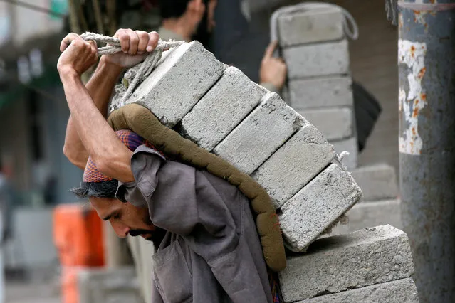 A labourer carries bricks on his back at a construction site in Karachi, Pakistan February 26, 2018. (Photo by Akhtar Soomro/Reuters)