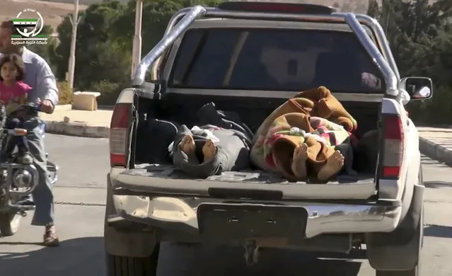 This frame grab from video provided by Muaz al-Shami, Syrian Revolution Network, an opposition activist media organization, that is consistent with independent AP reporting, shows two bodies lying down in the open back of a pick-up truck after airstrikes killed over 20 people, in the northern rebel-held village of Hass, Syria, Wednesday, October 26, 2016. A team of first responders, the Syrian Civil Defense in Idlib, said at least 50 were wounded in the raids that used parachute mines, targeting the residential area and schools in the village of Hass.  Most of those killed were children, the group said on its Facebook page. (Photo by Muaz al-Shami/Syrian Revolution Network via AP Photo)