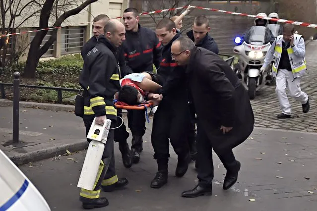 A victim is evacuated on a stretcher on January 7, 2015 after armed gunmen stormed the offices of the French satirical newspaper Charlie Hebdo in Paris. (Photo by Martin Bureau/AFP Photo)