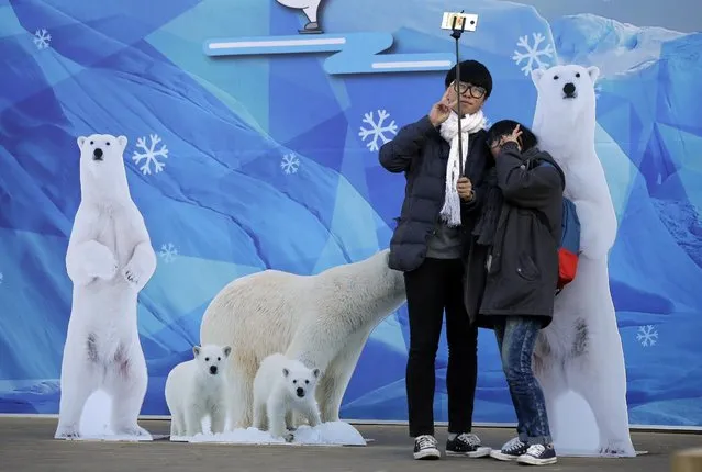South Korean students Kim Gun-ho, left, poses with his friend Lee So-yeon for a selfie using a selfie stick near Seoul City Hall at Seoul Plaza in Seoul, South Korea, Tuesday, January 6, 2015. (Photo by Lee Jin-man/AP Photo)