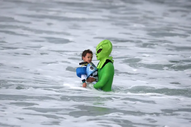 Oliver Quiros, 3, (L) dressed as an astronaut, and his father Andre Quiros, 31, dressed as an alien, wade back into the ocean as they compete in the Haunted Heats Halloween Surf Contest in Santa Monica, California, U.S., October 29, 2016. (Photo by Lucy Nicholson/Reuters)