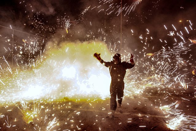 A reveler takes part in the “Nit de l'Alba” (Night of Dawn) of the traditional festivities of the city of Elche, Spain, late 13 August 2024. (Photo by Pablo Miranzo/EPA/EFE)