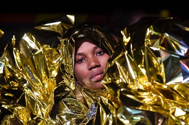 A woman wrapped in a survival foil blanket rests aboard the Topaz Responder ship run by Maltese NGO Moas and the Italian Red Cross after a rescue operation of migrants and refugees, early morning on November 5, 2016 off the coast of Libya. (Photo by Andreas Solaro/AFP Photo)