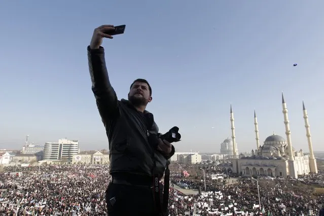 A man takes pictures of himself, with crowds of people and the Heart of Chechnya mosque seen in the background, during a rally to protest against satirical cartoons of prophet Mohammad, in Grozny, Chechnya January 19, 2015. (Photo by Eduard Korniyenko/Reuters)
