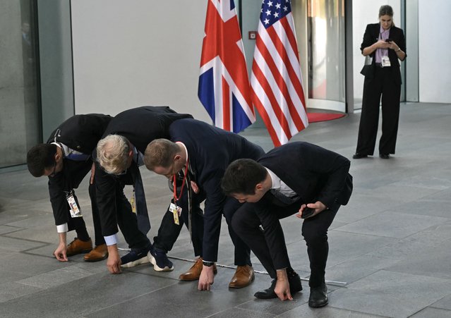 Staff members put names on the floor for the family photo of the “Quad meeting” held by the German Chancellor, the US President, the French President and the British Prime Minister at the Chancellery in Berlin, on October 18, 2024. (Photo by Andrew Caballero-Reynolds/AFP Photo)