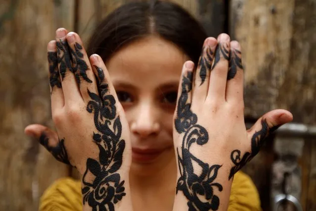 A Yemeni girl shows her henna-decorated hands ahead of the Eid al-Fitr holiday marking the end of the Muslim holy month of Ramadan, in Sanaa, Yemen June 14, 2018. (Photo by Mohamed al-Sayaghi/Reuters)