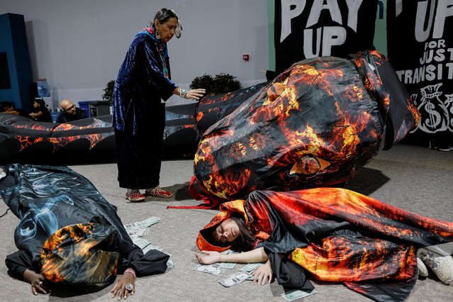 Activists lie next to fake currency bills as they participate in a protest action during the United Nations climate change conference COP29 in Baku, Azerbaijan on November 20, 2024. (Photo by Maxim Shemetov/Reuters)