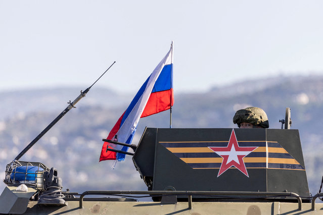 A Russian soldier rides on an infantry fighting vehicle, part of a Russian military convoy heading towards Hmeimim air base in Latakia, on the coast of Syria, on December 14, 2024. (Photo by Umit Bektas/Reuters)