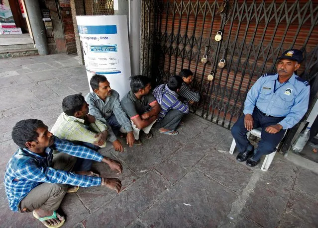 People sit on a floor as they wait for a bank to open in Chandigarh, India, November 15, 2016. (Photo by Ajay Verma/Reuters)