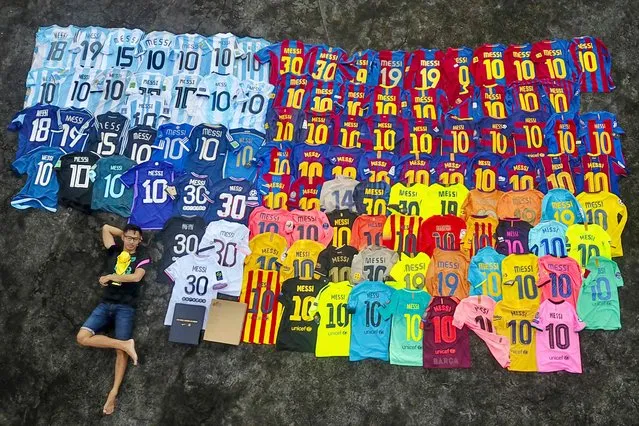 This aerial photo taken on June 2, 2023 shows Surya Wijaya Ang taking posing  for a selfie next to his collection of football jerseys adorned with Argentine footballer Lionel Messi's name, in Banda Neira. Indonesian fans of Lionel Messi expressed dismay on June 16 after the football star pulled out of a friendly match, including a superfan taking a 12-hour boat and plane journey to the sell-out game who accused organisers of false advertising. (Photo by Surya Wijaya Ang/AFP Photo)