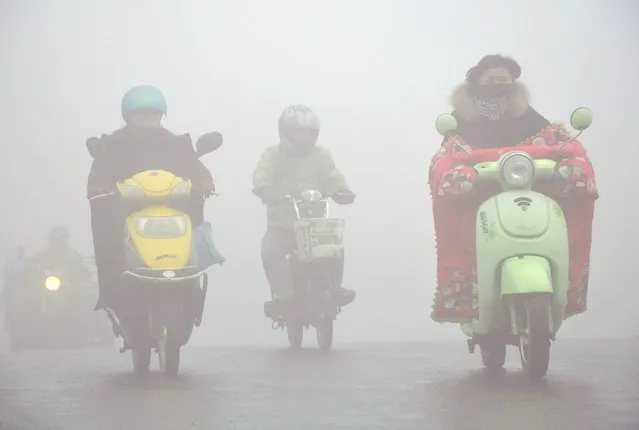 People ride their vehicles in the smog in Yangzhou, Jiangsu province, December 21, 2015. (Photo by Reuters/China Daily)