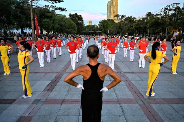 The photo taken on July 3, 2023 shows local residents taking part in an aerobics exercise at a square in Jiamusi, in northeastern China's Heilongjiang province. (Photo by Jade Gao/AFP Photo)
