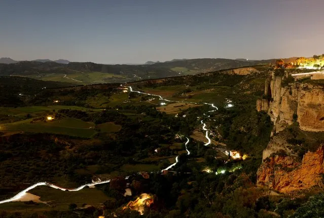 Trails of headlamps are seen in the night as runners make their way to the finish line (top R) as they participate in the running category during the XXIII 101km international competition, where about 9,000 participants run a track through the Serrania de Ronda (Ronda Mountain Range) in less than 24 hours, organised by the 4th Tercio (Regiment) Alejandro Farnesio of the Spanish Legion, in Ronda, Spain, May 15, 2022. (Photo by Jon Nazca/Reuters)