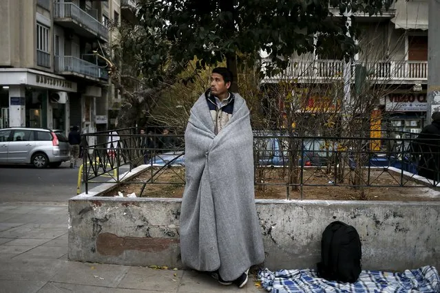 A stranded Afghan migrant covers himself with a blanket in Victoria square in Athens, Greece, December 30, 2015. (Photo by Alkis Konstantinidis/Reuters)