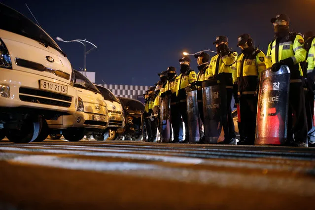 South Korean policemen block the road as farmers march with their trucks toward Seoul to attend a weekend protest calling for South Korean President Park Geun-hye to step down, at a tollgate in Ansung, South Korea, November 25, 2016. (Photo by Kim Hong-Ji/Reuters)