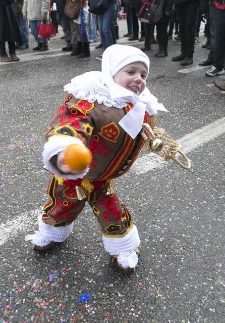 Hugo Belleri, a three-year-old boy and the youngest Gilles of Binche, throws an orange while taking part in the parade during the carnival event in Binche February 17, 2015. (Photo by Yves Herman/Reuters)