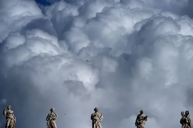 Heavy clouds are seen above statues of the Vatican before the Angelus prayer of Epiphany's day on January 6, 2016. (Photo by Gabriel Bouys/AFP Photo)