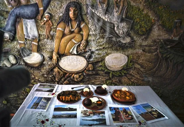 A mural depicting the preparation of casabe along with other yuca root dishes are seen at the Yucasabi restaurant, in Havana, Cuba, Saturday, May 13, 2023. Casabe was among the first native products embraced by the Spaniards upon their arrival. They incorporated it into their diet, partly because of its durability. It can last months once baked. (Photo by Ramon Espinosa/AP Photo)